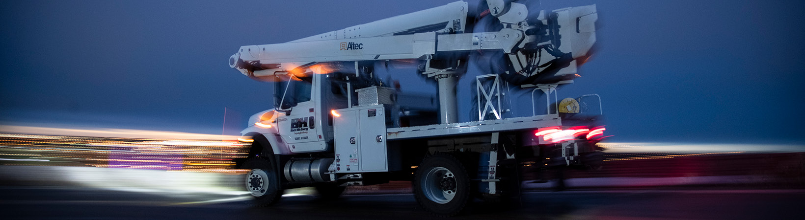 Black Hills Energy service truck driving with motion-blurred lights 