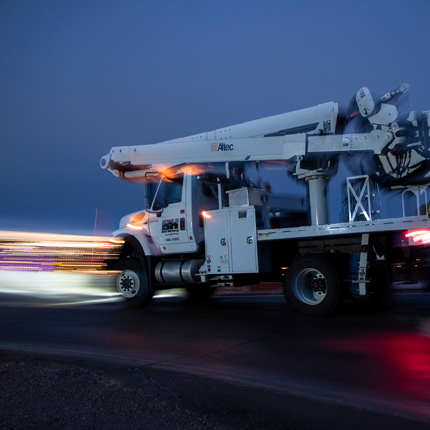 Black Hills Energy service truck driving with motion-blurred lights 