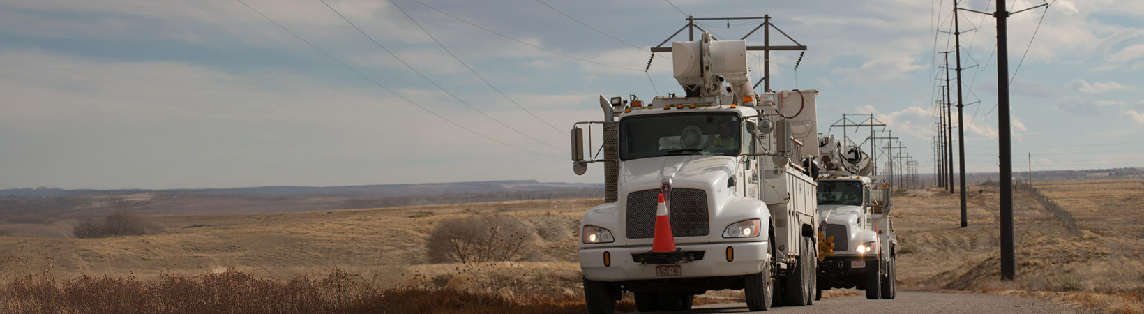 Black Hills Energy service trucks driving next to power lines