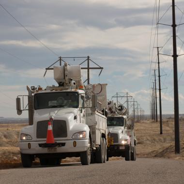 Black Hills Energy service trucks driving next to power lines