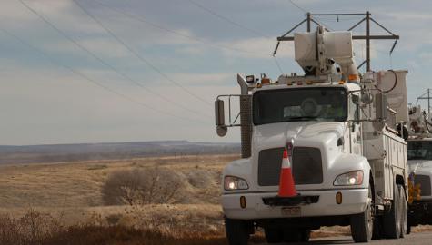 Black Hills Energy service trucks driving next to power lines